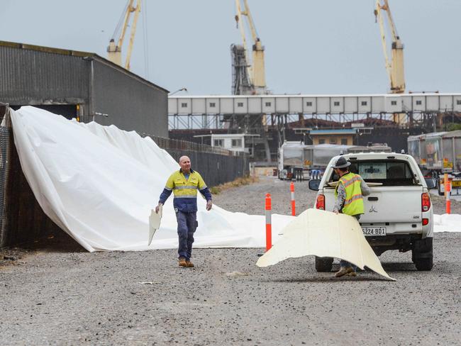 ADELAIDE, AUSTRALIA - NewsWire Photos FEBRUARY 2, 2023: Workers collect debris from the remains of a giant inflatable storage silo at Hallet Group at Berth 25 in Port Adelaide after exploding in high winds. Picture: NCA NewsWire / Brenton Edwards