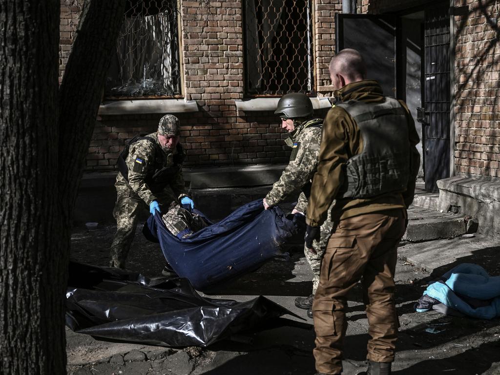 Military emergency service members remove the body of a dead Ukrainian serviceman in the area of a research institute, part of Ukraine's National Academy of Science, after a strike, in northwestern Kyiv. Picture: AFP