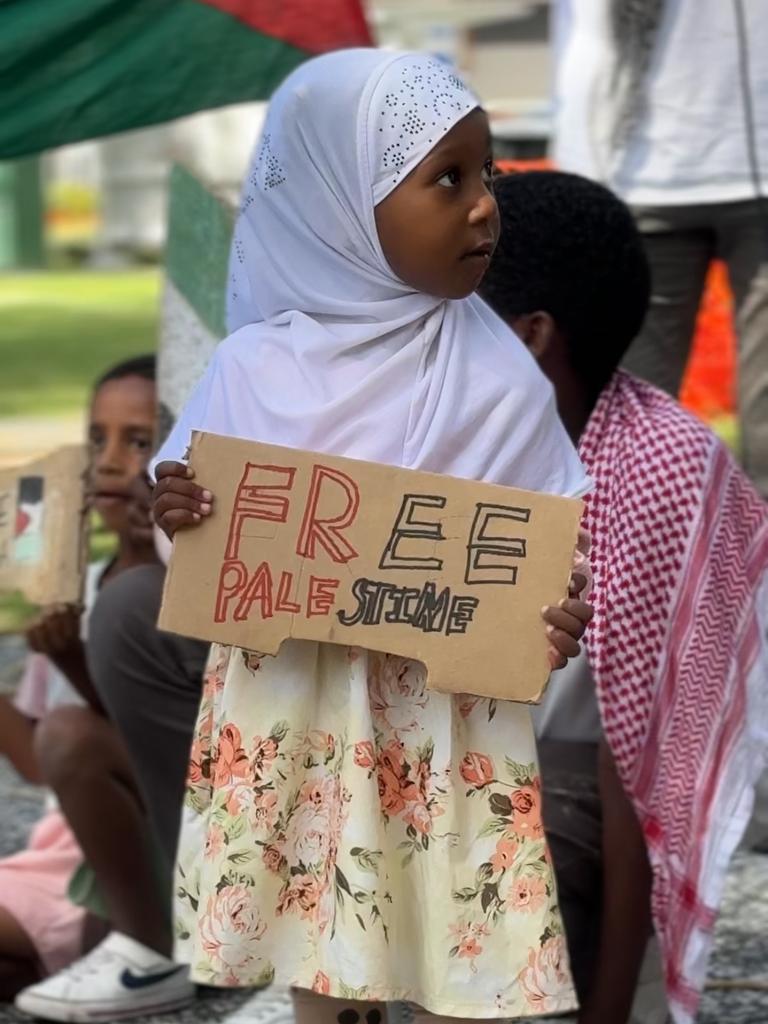 A child holding a 'Free Palestine' poster at a Palestine solidarity rally held at Victoria Park, Broadbeach on 18.11.23. Picture: Amaani Siddeek