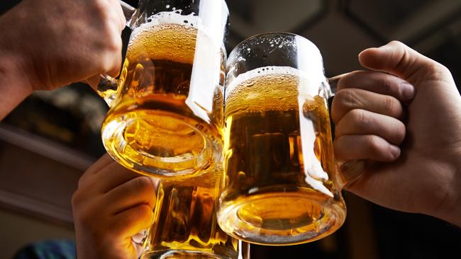 Hands of three men toasting with beer