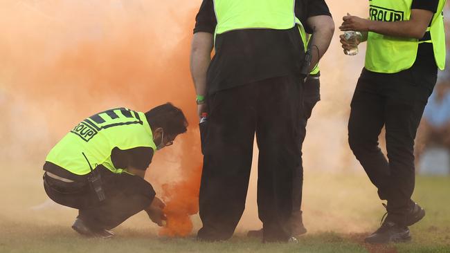 Security try extinguish a flare during the round five NRL match between the Cronulla Sharks and the Wests Tigers at PointsBet Stadium. Picture: Getty Images