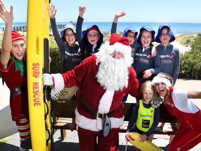 SANTA ARRIVES IN A CHOPPER AT GRANGE BEACH/SLSC. Santa and his Elves fly in by helicopter to meet Grange nippers. (L-r) Grange SLSC nippers - Grace, Charlotte, Erin, Lexie, Jake, Isla. Pictured on the 18th December, 2021. Picture: Tricia Watkinson