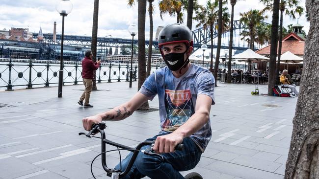A mask-wearing rider is seen at Circular Quay in Sydney.. Picture: NCA NewsWire/Flavio Brancaleone
