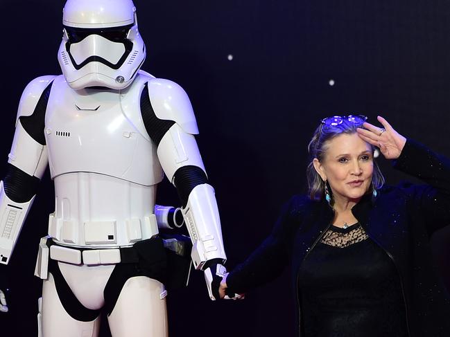 (FILES) In this file photo taken on December 16, 2015 US actress Carrie Fisher (R) poses with a storm trooper as she attends the opening of the European Premiere of 