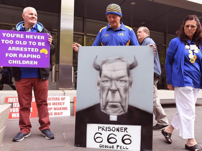 Survivors of church abuse hold placards outside at the Melbourne County Court to hear the sentencing of Cardinal George Pell on Tuesday. Picture: AFP