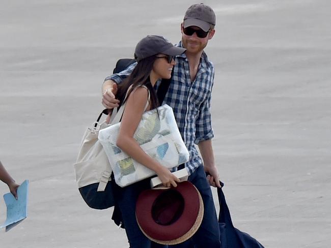 Prince Harry and Meghan Markle walk along the runway at the airport in Africa. Photo: The Sun