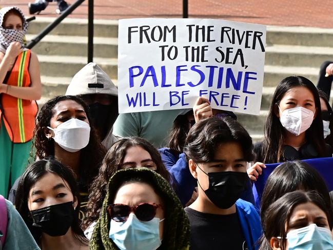 A participant holds a placard as students gather during a "Walkout to fight Genocide and Free Palestine" at Bruin Plaza at UCLA (University of California, Los Angeles) in Los Angeles on October 25, 2023. Thousands of people, both Israeli and Palestinians have died since October 7, 2023, after Palestinian Hamas militants based in the Gaza Strip, entered southern Israel in a surprise attack leading Israel to declare war on Hamas in Gaza the following day. (Photo by Frederic J. BROWN / AFP)