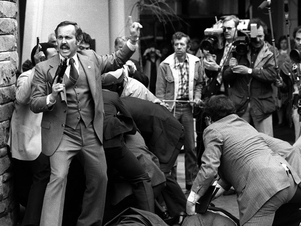 John Hinckley is wrestled to the ground after he slipped in behind cameramen, fired his weapon between them. 