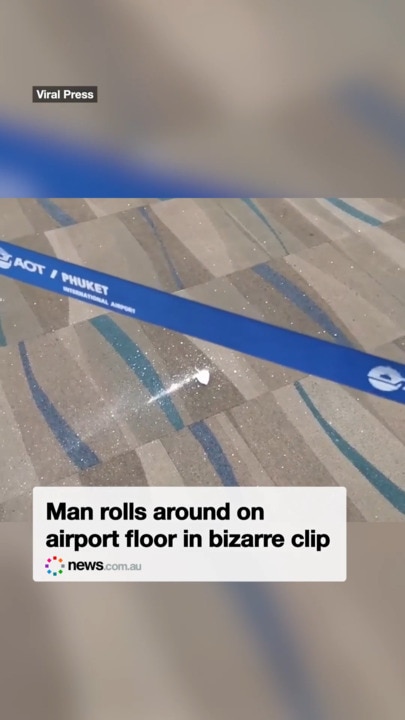 Man rolls around on airport floor in bizarre clip