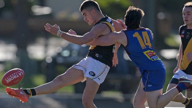 NFNL: Heidelberg’s Kai Kearns gets a kick away under pressure from Banyule’s Riley Loton. Picture: Andy Brownbill