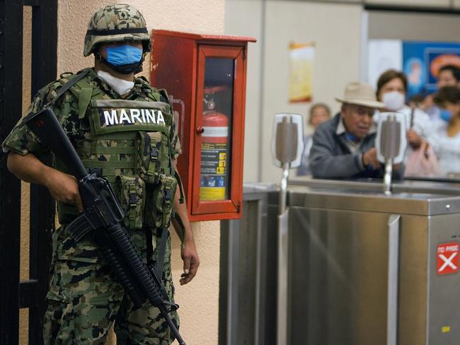  A member of the Mexican Navy stands guard at a subway station in Mexico City in 2009 after an outbreak of swine flu virus. Picture: Supplied 