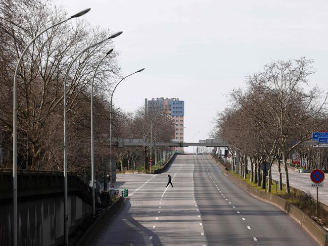 A pedestrian crosses the closed and empty Paris ring road, Boulevard Peripherique, next to the Porte d'Aubervilliers, in Paris. Picture: AFP