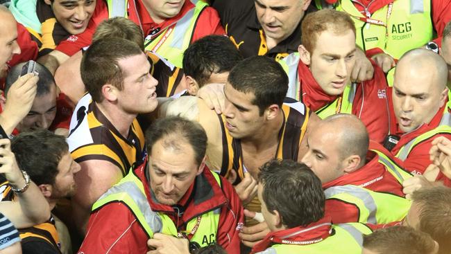 Security surround Lance Franklin after he kicked his 100th goal for the season.