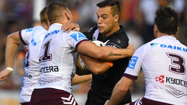 Luke Brooks of the Tigers is tackled by Lewis Brown of the Sea Eagles.