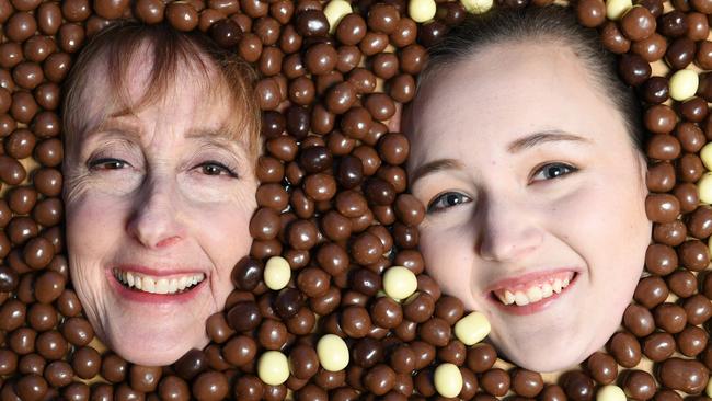 Oldest Robert Menz confectioner Nancy Carroll, 72, and its youngest employee Caitlin Searles, 19, covered in Fruchocs. Image AAP/Mark Brake