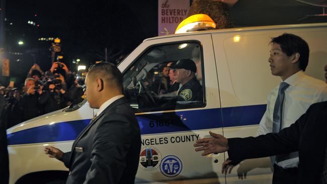 A coroner’s van carrying Houston’s body leaves the Beverly Hilton.