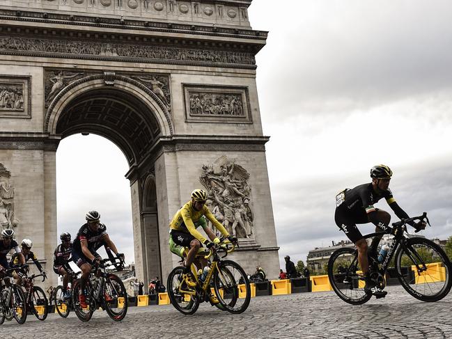 (FILES) This file photo taken on July 26, 2015 shows Great Britain's Christopher Froome, wearing the overall leader's yellow jersey, (2nd R) riding with the pack past the Arc de Triomphe in Paris during last stage of the 102nd edition of the Tour de France cycling race on July 26, 2015, between Sevres and Paris. / AFP PHOTO / ERIC FEFERBERG