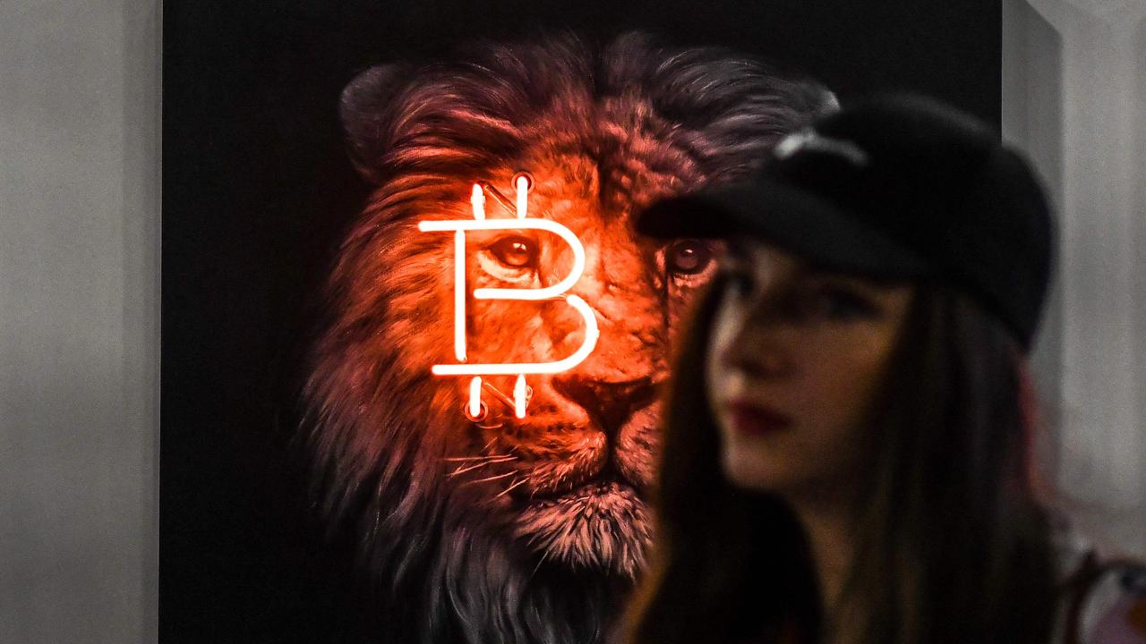 A woman walks past a bitcoin themed art installation during the Bitcoin 2022 Conference in April. Picture: Chandan Khanna/AFP