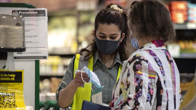 Woolworths staff photographed handing out mask's to shoppers at Bondi Junction on Tuesday. Picture: Monique Harmer