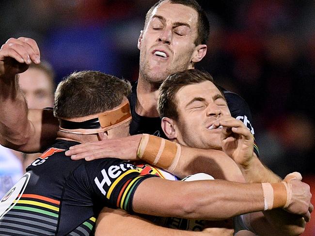 Ryley Jacks of the Titans is tackled by Mitchell Kenny (left) and Isaah Yeo of the Panthers. Picture: AAP