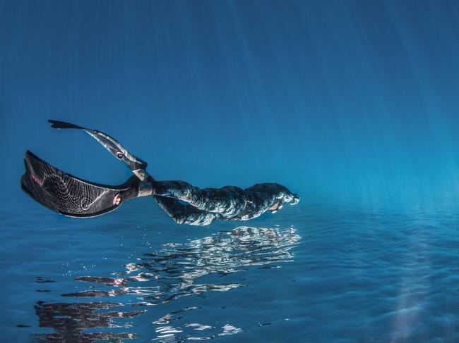 David Alpert: A freediver appears to be flying in the calm, blue waters of the Aegean Sea. Greece