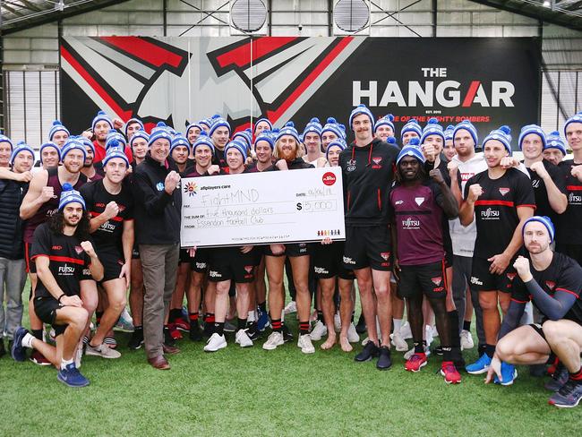 Essendon players present a cheque to Neale Daniher this week. Picture: Michael Dodge/Getty Images