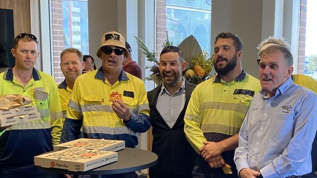 Former Liverpool councillor Peter Ristevski (in suit) with union members eating pizza outside the chambers.