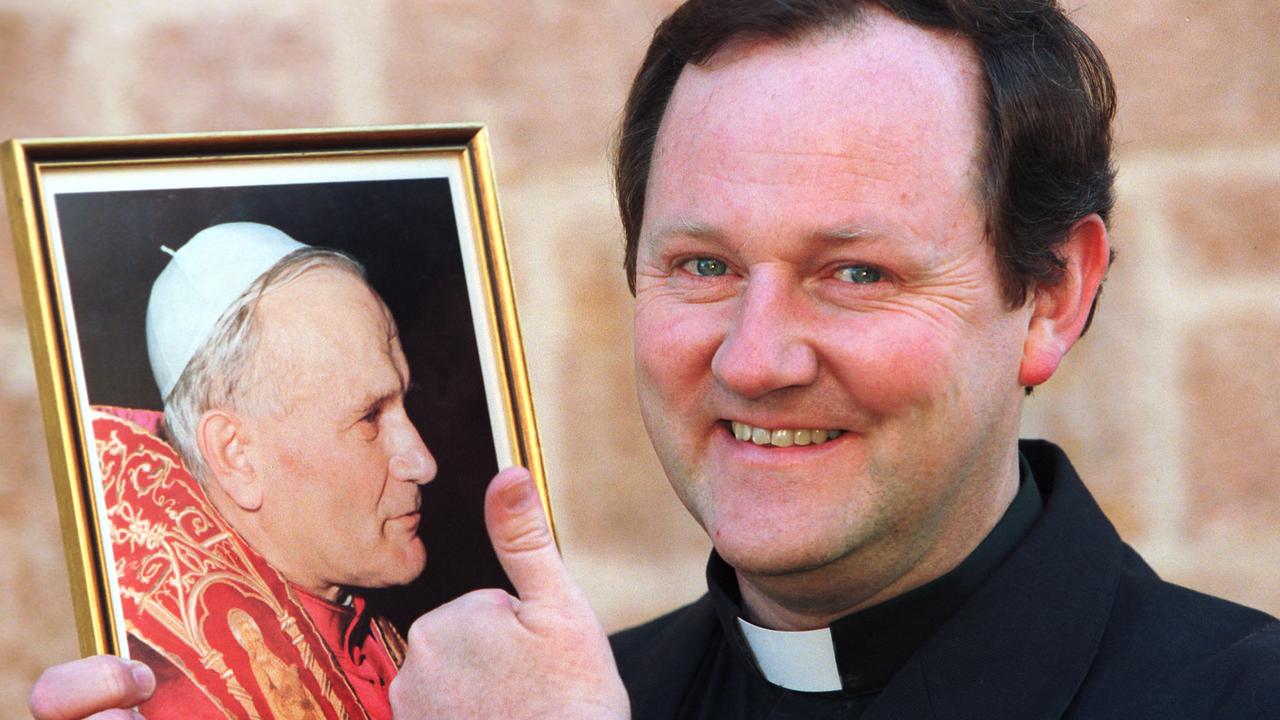 Former Blackfriars Primary School principal and Catholic priest Father Martin Wallace in October 2000, giving the thumbs up to a photograph of Pope John Paul II. Picture: Michael Milnes