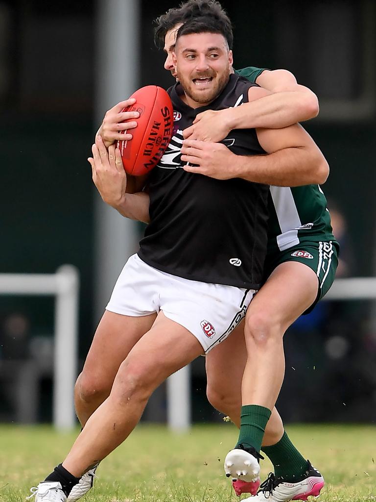 Essendon District: Roxburgh Park’s Matthew Patane gets tackled high against Airport West. Picture: Andy Brownbill