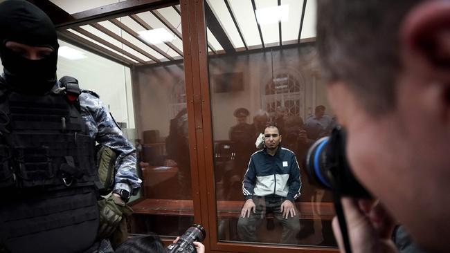 A man suspected of taking part in the attack sits in the defendant cage as he waits for his pre-trial detention hearing at the Basmanny District Court in Moscow. Picture: AFP.