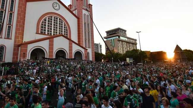 People surround a church during a mass in memoriam of the players.