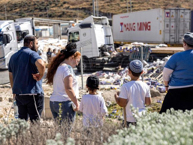 Israeli right-wing activists look at the damaged aid trucks. Picture: AFP