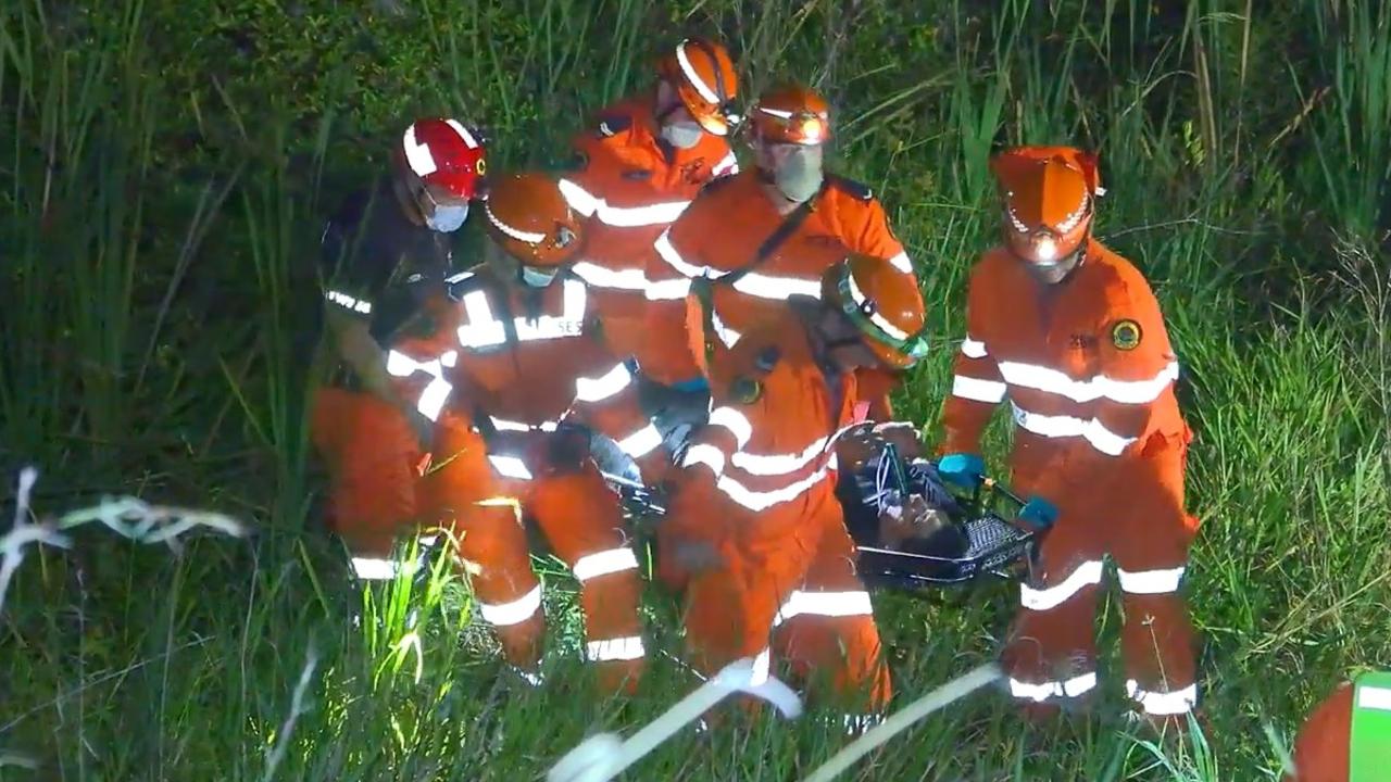 State Emergency Service volunteers rescue a man after a crash that happened in an exit lane from the Pacific Highway at Moonee Beach on March 9, 2022.