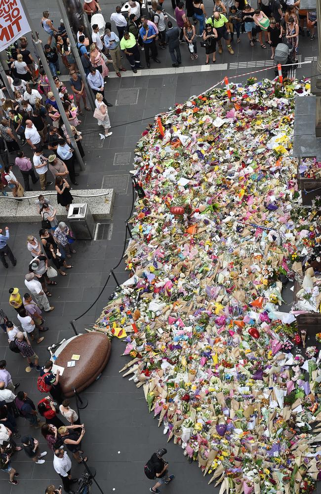 Flower tributes swamp a city street corner. Picture: Nicole Garmston