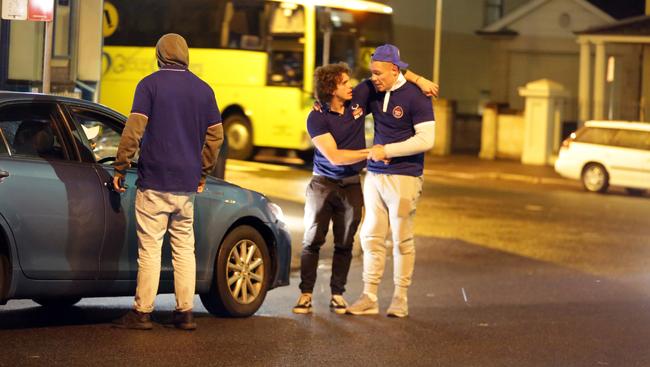 Party’s over... Player helps his mate to waiting uber car. Picture: Christian Gilles