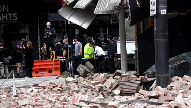 People gather near a damaged building in Chapel St Melbourne after today's earthquake. Picture: AFP