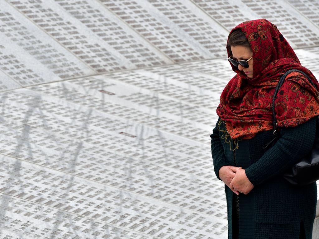 A Bosnian Muslim woman, walks by the memorial wall containing the names of the victims. Picture: AFP 