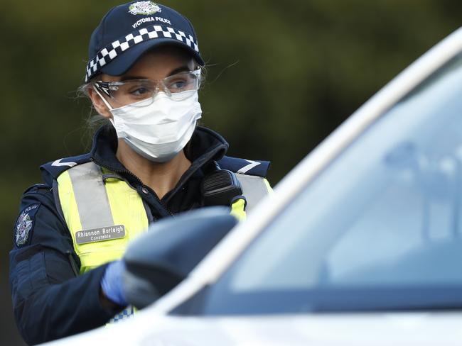 MELBOURNE, AUSTRALIA - JULY 02: Police check the identification of members of the public at a pop up road block in Broadmeadows to ensure they have legitimate reasons for leaving one on the hotspots, July 02, 2020 in Melbourne, Australia. Lockdowns across Melbourne have come into effect for residents of suburbs identified as COVID-19 hotspots following a spike in new coronavirus cases through community transmission. From midnight Wednesday 1 July, residents of 10 postcodes will only be able to leave home have for exercise or work, to buy essential items including food or to access childcare and healthcare. Businesses and facilities in these lockdown areas will also be restricted and cafes and restaurants can only open for take-away and delivery. The restrictions will remain in place until at least 29 July. (Photo by Darrian Traynor/Getty Images)