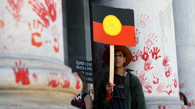 Protesters leave red paint hand prints on a pillar during a protest outside the South Australian parliament. Picture: AAP