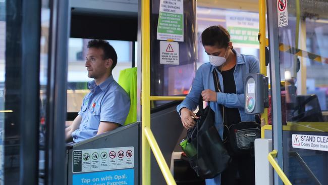 A woman wearing a mask as a preventative measure against the coronavirus disease (COVID-19) boards a public bus at Railway Square bus station in Sydney.