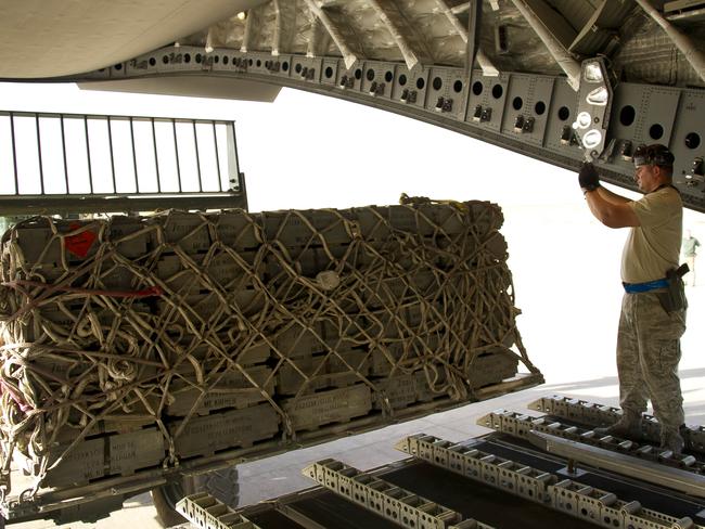 A United States Defence Force member guides a forklift during the unloading of military stores from the Royal Australian Air Force C-17 Globemaster at Erbil Airport in northern Iraq.