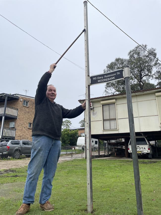 Bruce Broadhurst outside his home, showing the flood record he keeps. The point he is touching with his cane is the 1986 floods, the biggest on record. Picture: Paul Brescia