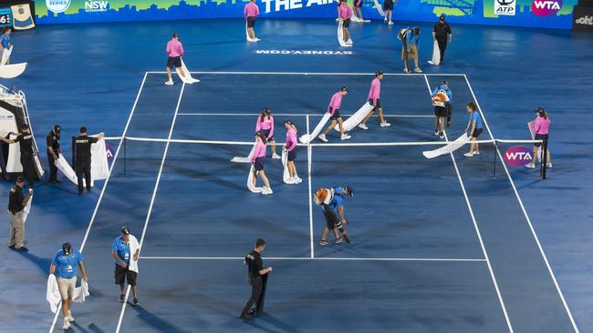 Staff dry the court in Rod Laver Arena. (AAP Image/Craig Golding)