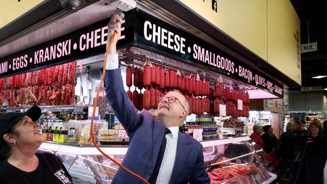 Prime Minister Anthony Albanese helps plug in some power at a market stall while visiting the Adelaide Central Market on Friday. Picture: NCA NewsWire / Kelly Barnes