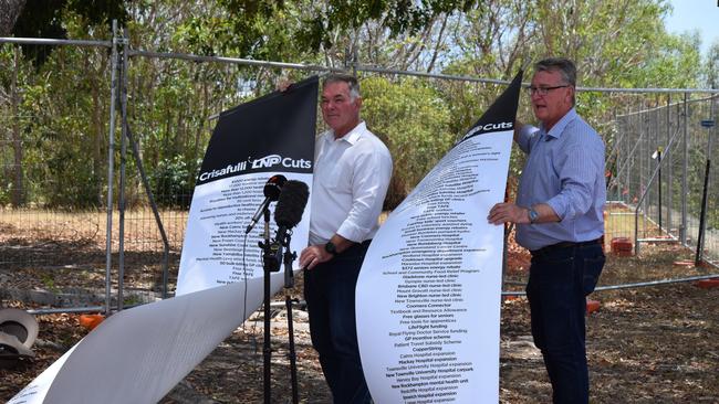 Member for Townsville Scott Stewart and Member for Mundingburra Les Walker show their lists of what they say the LNP will cut if elected during a press conference on Wednesday in Townsville.