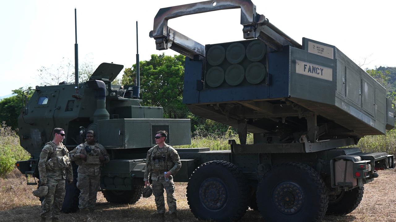 US army soldiers standing next to their high mobility artillery rocket system (HIMARS) launcher Australia will now acquire. Picture: AFP