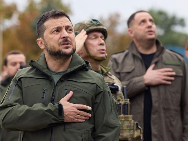 TOPSHOT - This handout picture taken and released by Ukrainian Presidential press-service on September 14, 2022 shows Ukrainian president Volodymyr Zelensky taking part in the state's flag raising in the de-occupied city of Izyum, Kharkiv region. - Zelensky on September 14, 2022 visited the east Ukraine city of Izyum, the military said, one of the largest cities recently recaptured from Russia by Kyiv's army in a lightning counter-offensive. (Photo by UKRAINIAN PRESIDENTIAL PRESS SERVICE / AFP) / RESTRICTED TO EDITORIAL USE - MANDATORY CREDIT "AFP PHOTO / " - NO MARKETING NO ADVERTISING CAMPAIGNS - DISTRIBUTED AS A SERVICE TO CLIENTS