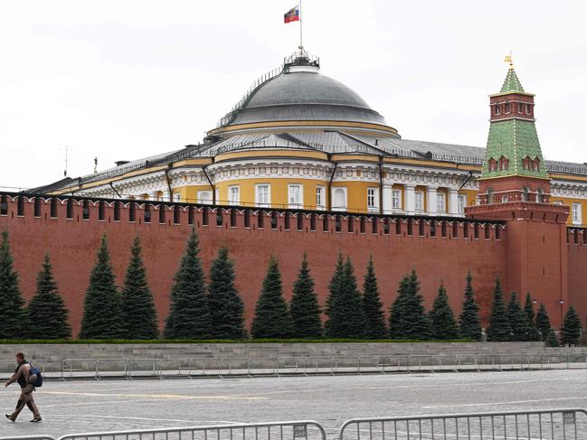 A man walks past the Kremlin wall as the Russian national flag flutters above the residence of the Russian president in Moscow on June 24. Picture: AFP