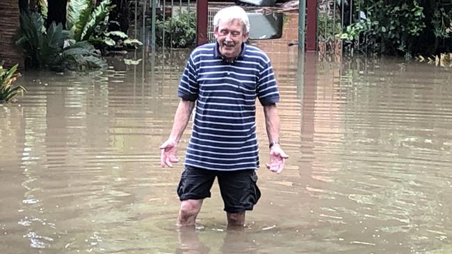 Carinya Rd resident Barry Lewis wades in his flooded garden. Picture: Lawrence Machado