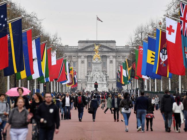 Pedestrians walk underneath flags of Commonwealth countries flying from flagpoles along the Mall leading to Buckingham Palace ahead of the opening of the biennial Commonwealth Heads of Government Meeting. Picture: Ben Stansall/AFP